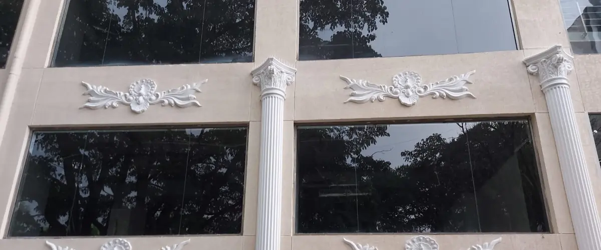 Close view of Corinthian capitals and carved panels between the windows