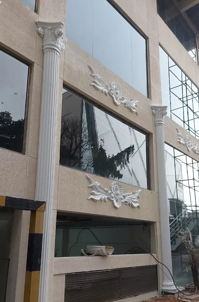 Column rising past two floors of glazing, with carved panels beside it