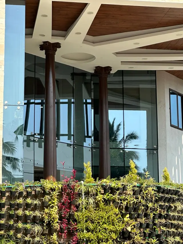 Columns at the glazed entrance above a green wall