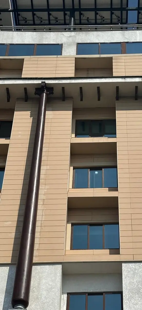 A column rising past the windows to the brackets under the cornice