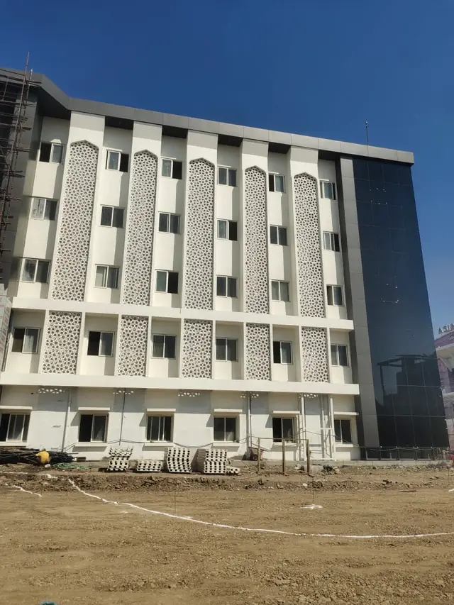 Side wing of the hospital with jali panels between the windows